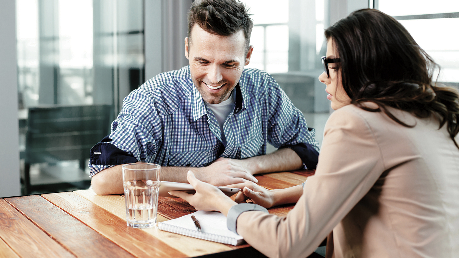 Businesswoman showing digital tablet and explaining to her colleague.