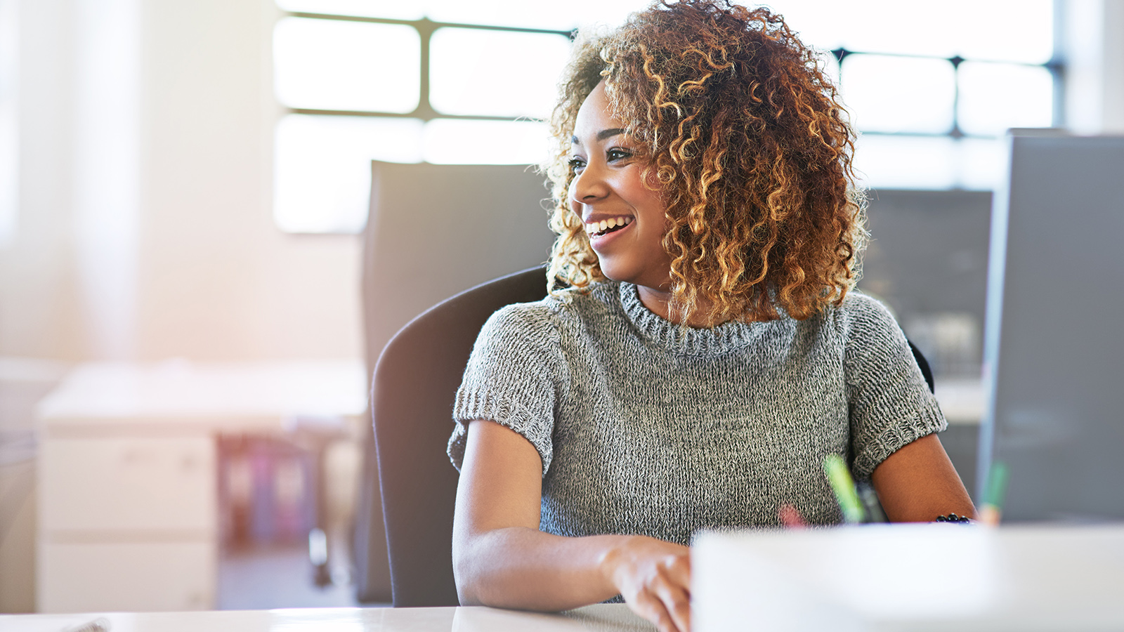 appy young african woman sitting at a business presentation
