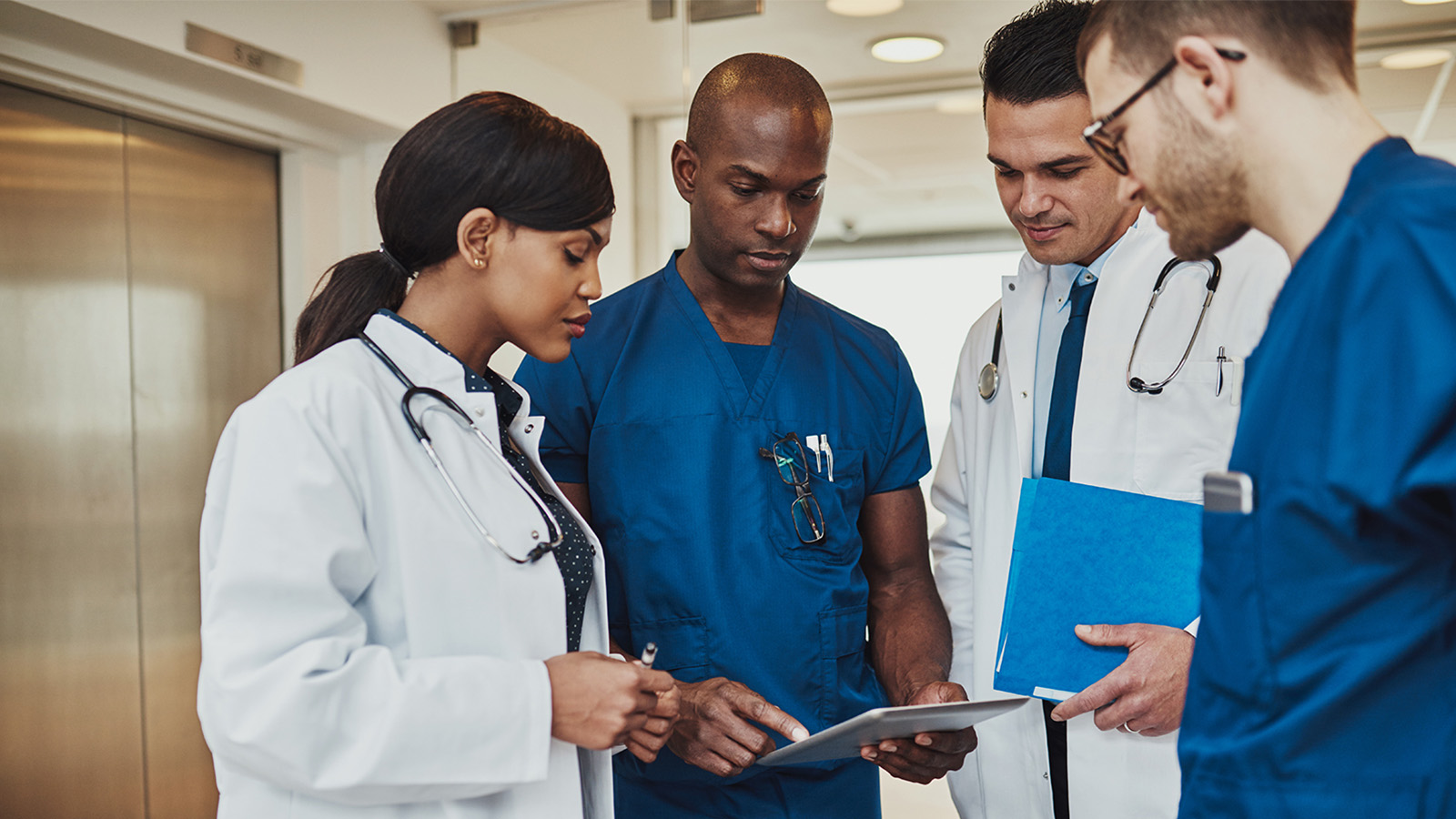 Group of medical staff discussing in clinic hallway