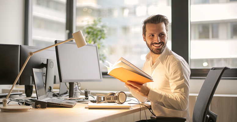 Smiling young man reading a book