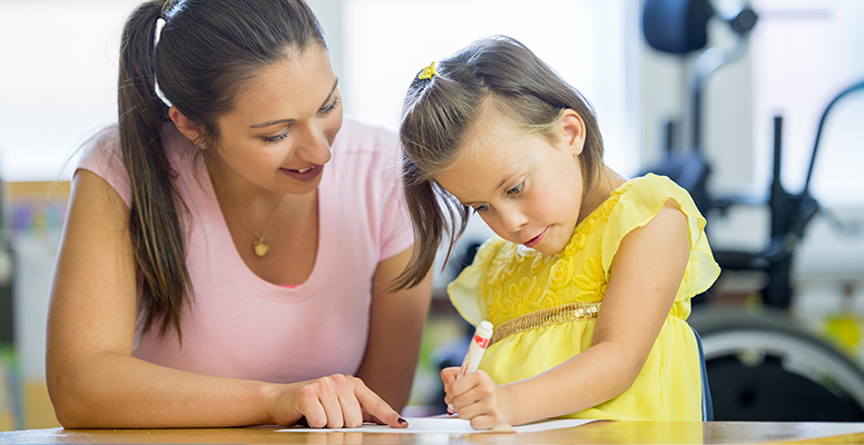 Loving young mother and little preschooler daughter sit at table drawing on paper together