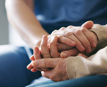 Cropped shot of a senior woman holding hands with a nurse