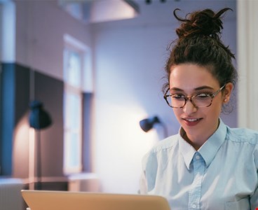 Young teenage female learning online on her laptop at home