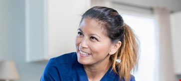 Healthcare nurse smiling at patient after exam