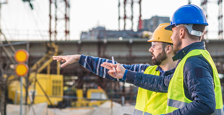 Two workers in production plant as team discussing