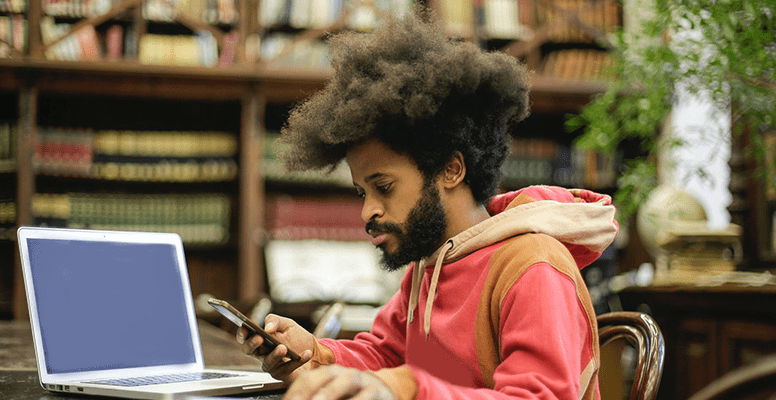 Man in Pink Long Sleeve Shirt Doing Research on mobile