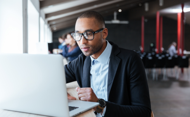 Young handsome businessman working with laptop in the office