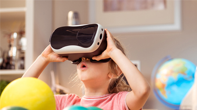 Little girl using virtual reality headset and being amazed