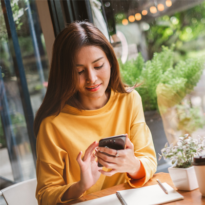 Young Asian beautiful woman using smart phone for business, online shopping, transfer money, financial, internet banking. in coffee shop cafe over blurred background.